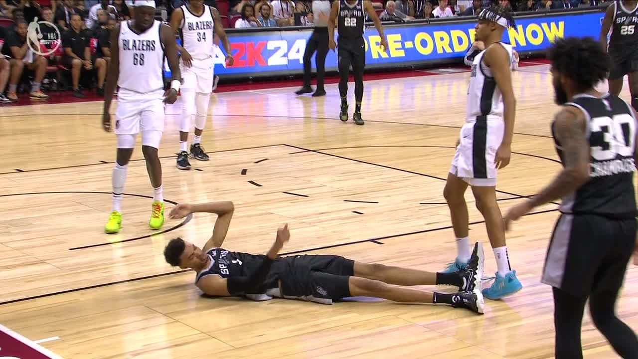 Victor Wembanyama falls to court after getting fouled on a drive in transition